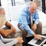 Sales and marketing executive selling to older couple on Apple computer